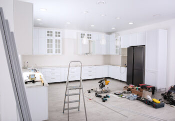 Renovated Kitchen Interior With Stylish Furniture, Refrigerator And Maintenance Equipment